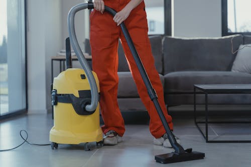 A professional cleaner vacuuming an office to maintain cleanliness.